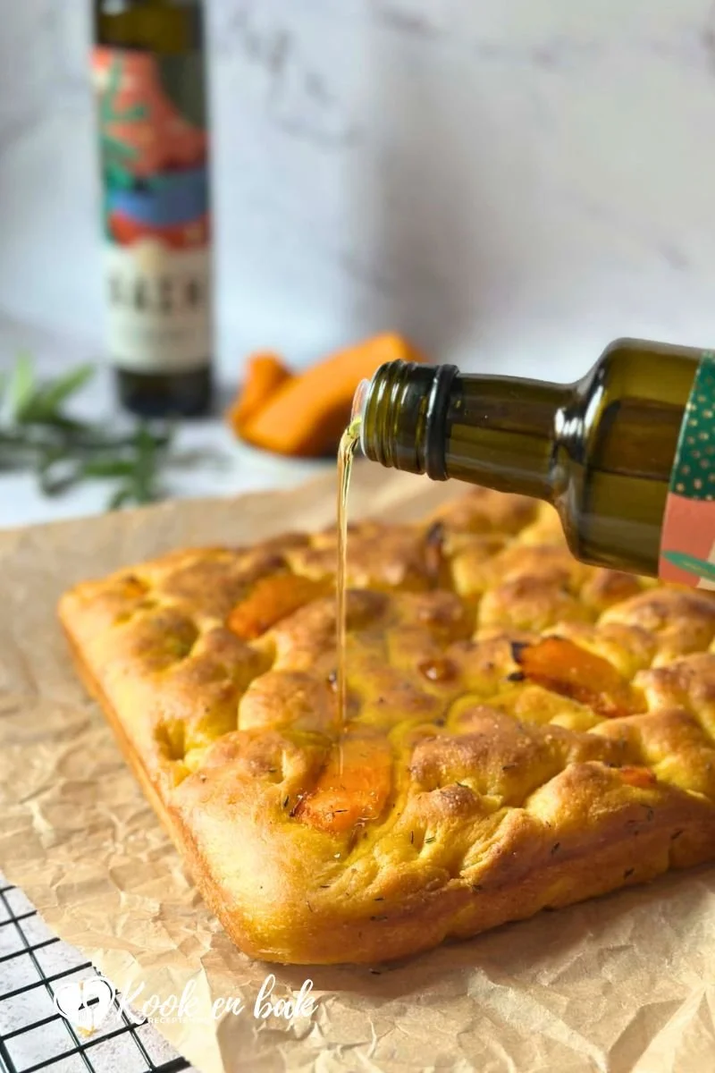 Extra vierge olijfolie schenken over pompoen focaccia