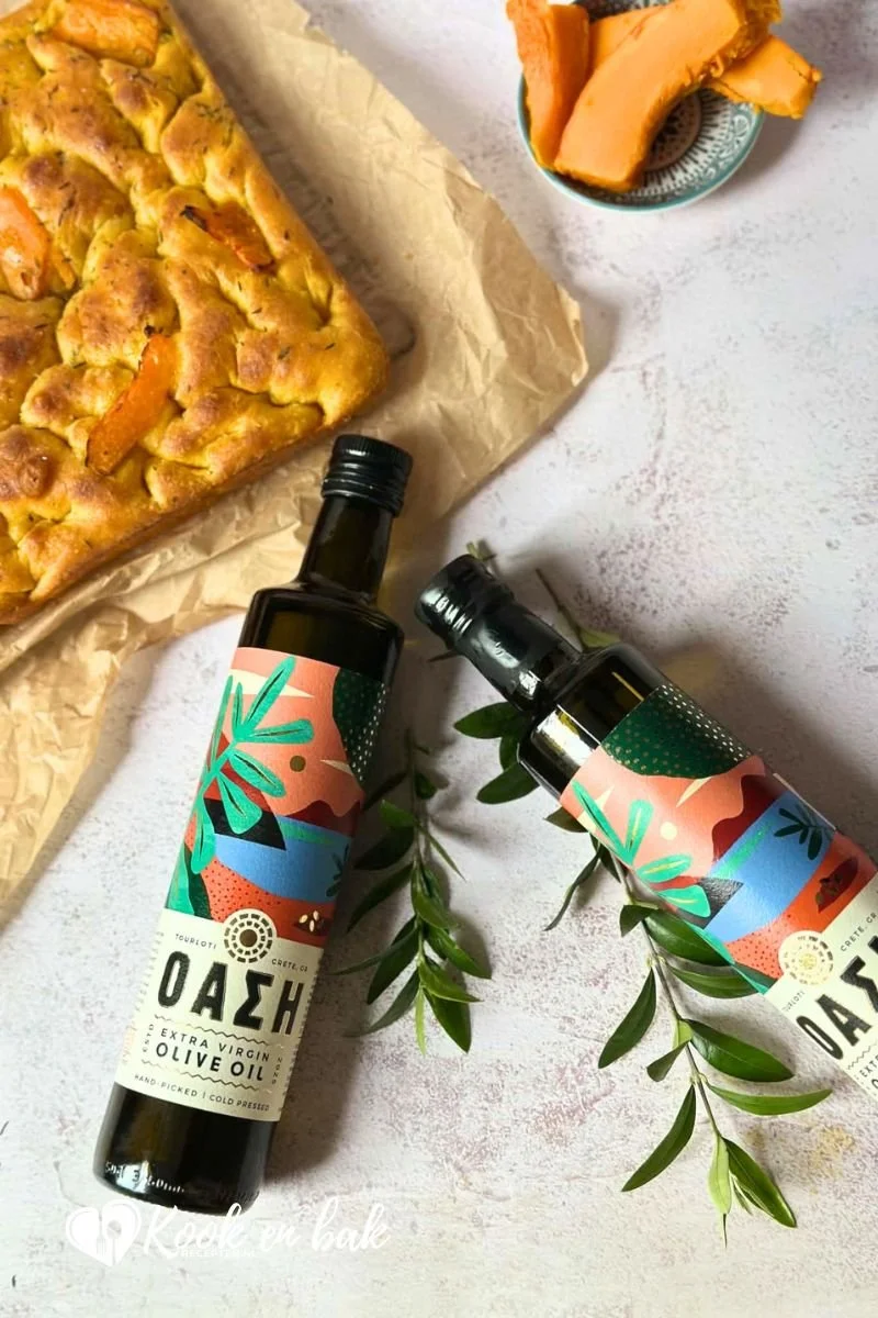 Flessen Oasi olijfolie naast zelfgemaakte pompoen focaccia